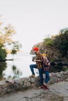 Bald guy with a beard and a blonde girl in bright hats are taking pictures with an old camera photo