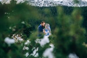 groom in a blue suit and bride in white in the mountains Carpathians photo