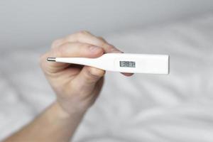 Hand holding a thermometer photo