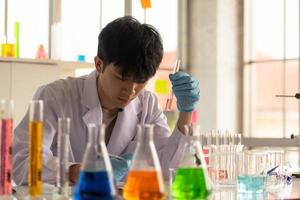 Asian young scientist lab testing and analysis chemical at the laboratory photo