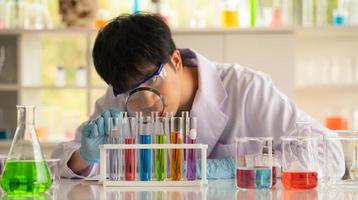 Joven científico asiático pruebas de laboratorio y análisis de productos químicos en el laboratorio foto