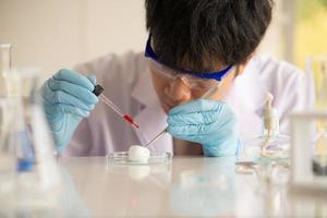 Asian young scientist lab testing and analysis chemical at the laboratory photo