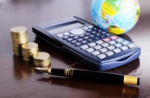 Calculator money coins with fountain pen and earth for loan money concept photo