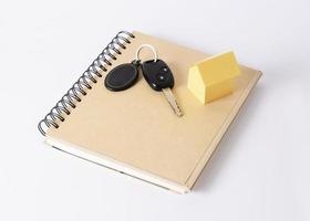 Key car and yellow house on book photo