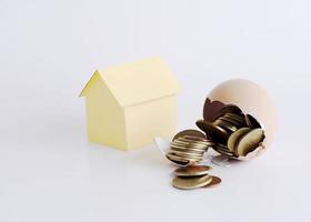 Broken egg with coins inside and House paper for Home loans money concept photo