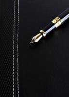 Close up of Fountain pen on leather cover book for Business concept photo