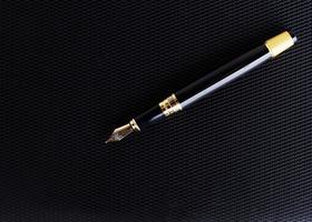 Close up of Fountain pen on leather cover book background photo