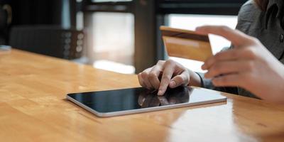 mujer pagando y comprando con tarjeta de crédito y teléfono inteligente móvil con computadora portátil y calculadora en el escritorio en la oficina en casa. e concepto de negocio. foto