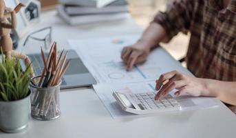 Cerrar las manos de la mujer del gerente financiero tomando notas cuando se trabaja en el informe foto