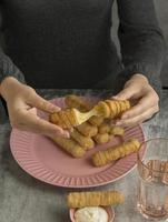 Woman enjoying some traditional tequenos photo