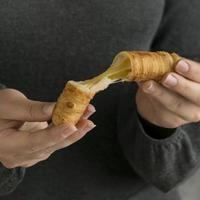 Close-up of hands holding a tequeno photo