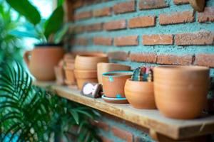 Closeup of empty clay pots on the wooden shelf with bricklayer wall background photo