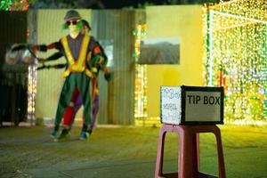 Selective focus on a tip box in front of a dancing performance on a public street. The Thai language means Thank you for the support. photo