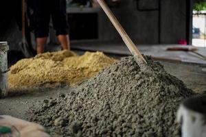 Selective focus on the surface of mixed cement pile with blurred background of sand at the construction site photo