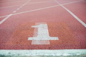 Textura abstracta y fondo de pista de atletismo vacía con el número uno en el suelo foto