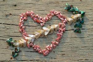 Top view of folding paper in little heart shape put on the wooden surface, Cupid's arrow photo