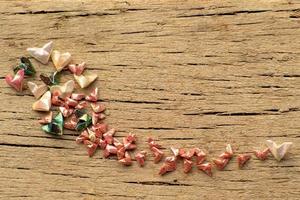 Top view of many pieces of folding paper in heart shape put randomly on the wooden plate. Happy Valentine's Day concept photo