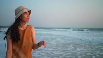 ung asiatisk kvinna som har en avkopplande promenad på stranden video