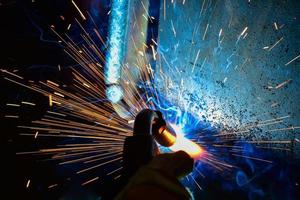 Welder, or craftsman, erecting technical industrial steel in factory photo