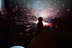 Welder, or craftsman, erecting technical industrial steel in factory photo