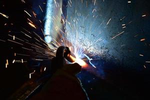 Welder, or craftsman, erecting technical industrial steel in factory photo