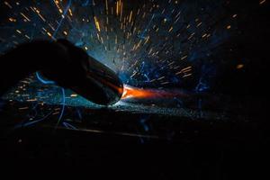 Welder, or craftsman, erecting technical industrial steel in factory photo