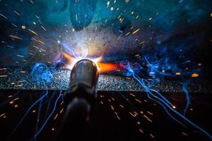 soldador, o artesano, erigiendo acero industrial técnico en fábrica foto