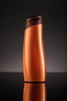 Bronze plastic bottle on a black background photo