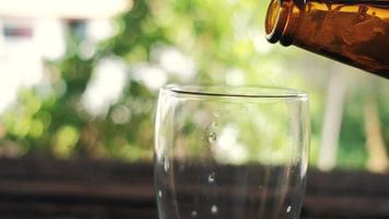 Bier aus der Flasche in ein Glas im Hinterhof gießen video