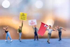 Miniature people, protesters holding signs, raising their hands for revolution