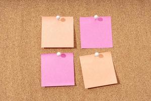 Group of four blank notes on a cork board for adding text and push pin. Mock up photo