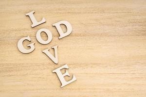 God is Love concept Words forming a cross on wooden table photo