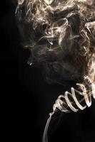 Abstract smoke from incane on black background.Look like the face. photo