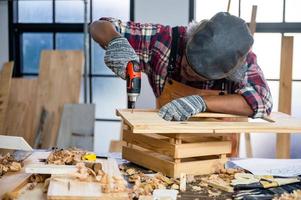 Carpintero profesional hombre que trabaja con la construcción de herramientas de la industria de la carpintería, taller de persona artesano con madera y equipos de madera foto