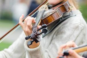 manos de una niña músico callejero con violín foto