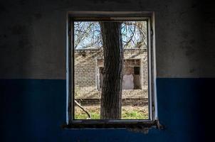 Vista desde la ventana de una casa abandonada abandonada en Ucrania