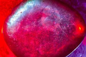 Mineral gem colorfully illuminated in macro capture showing abstract space type details photo