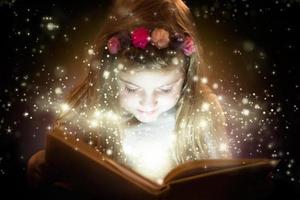 niña bonita leyendo un libro mágico
