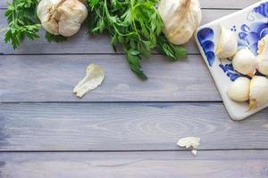 Garlic and parsley on wooden background