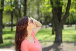 mujer mirando hacia arriba y con gafas de sol foto