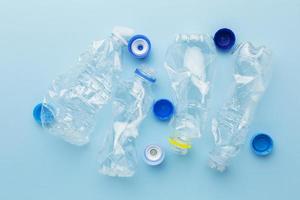Vista superior de botellas y tapas de residuos plásticos. foto
