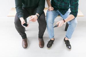 Young men using smart phones photo