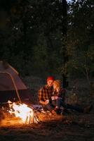 Young couple a guy and a girl in bright knitted hats stopped at a camping photo