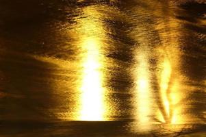 Bright yellow light reflections on water surface photo