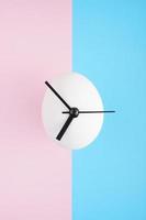 An egg clock on blue and pink background photo