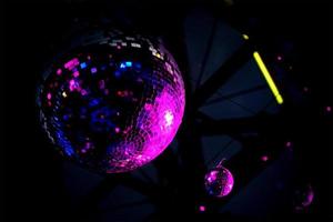 bola de discoteca reflejada en luz púrpura foto