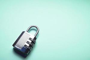 A shiny coded padlock on a bright turquoise background photo