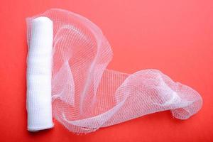 Sterile bandage on red background photo