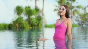 Young Asian Woman Relaxing Around an Outdoor Swimming Pool video