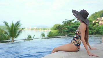 Young Asian Woman Relaxing Around an Outdoor Swimming Pool video